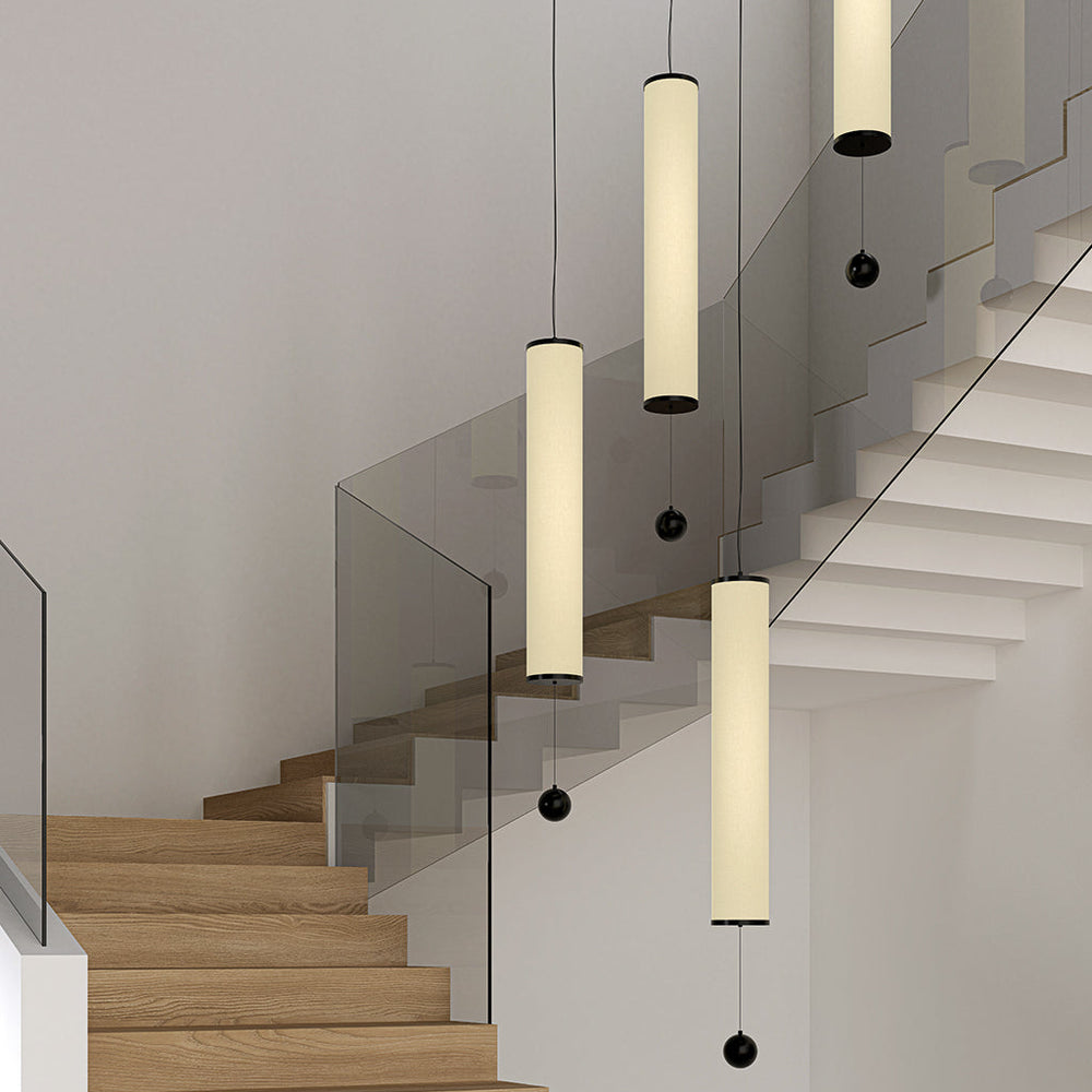 Vertical Nooi Large Pendant Lamps with ball weights hanging at staggered heights in a stairwell