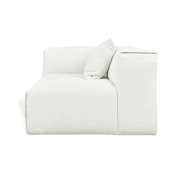 Elegant white textured modular sofa with designer cushion, blending modern comfort and refined aesthetics.