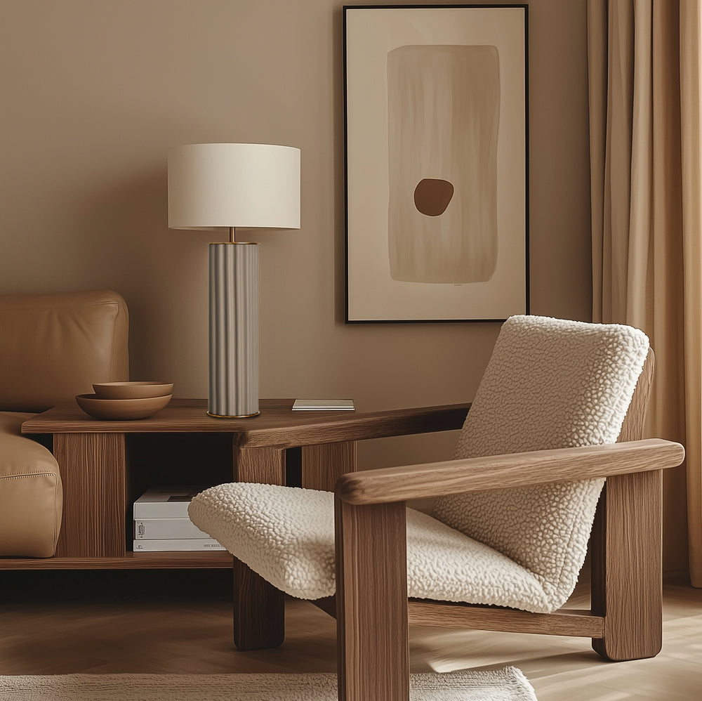 Cream fluted lamp on a wood console beside a boucle lounge chair and framed abstract print