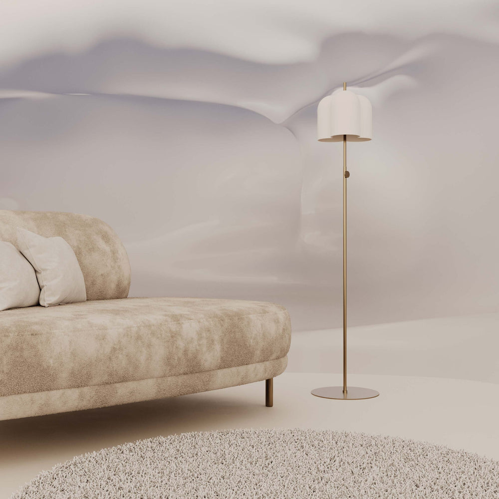Oket Floor Lamp in white and brass beside a textured cream sofa in a softly draped room