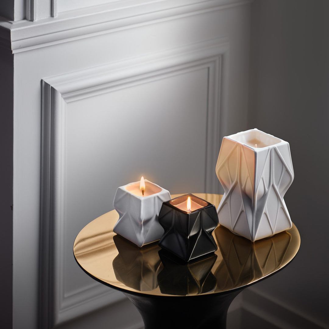 Prime Scented Candle Duo, Set of 2 — white and black candles lit on a brass side table with a larger white vessel