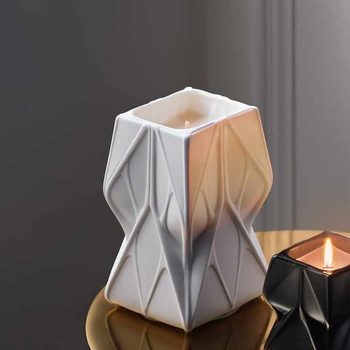 Prime Scented Candle — Tall white candle beside a lit black candle on a brass side table