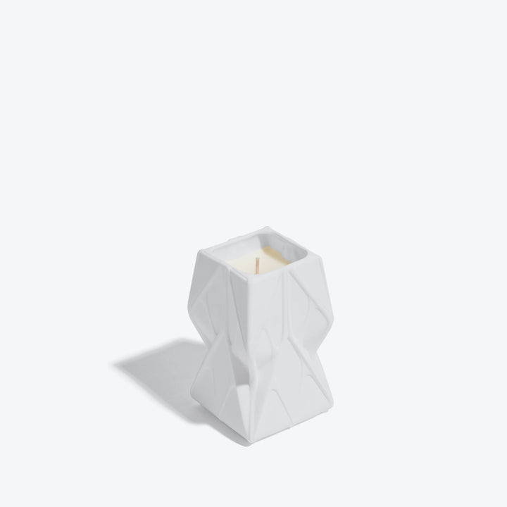 Prime Scented Candle — Tall white candle, three-quarter view showing the folded relief