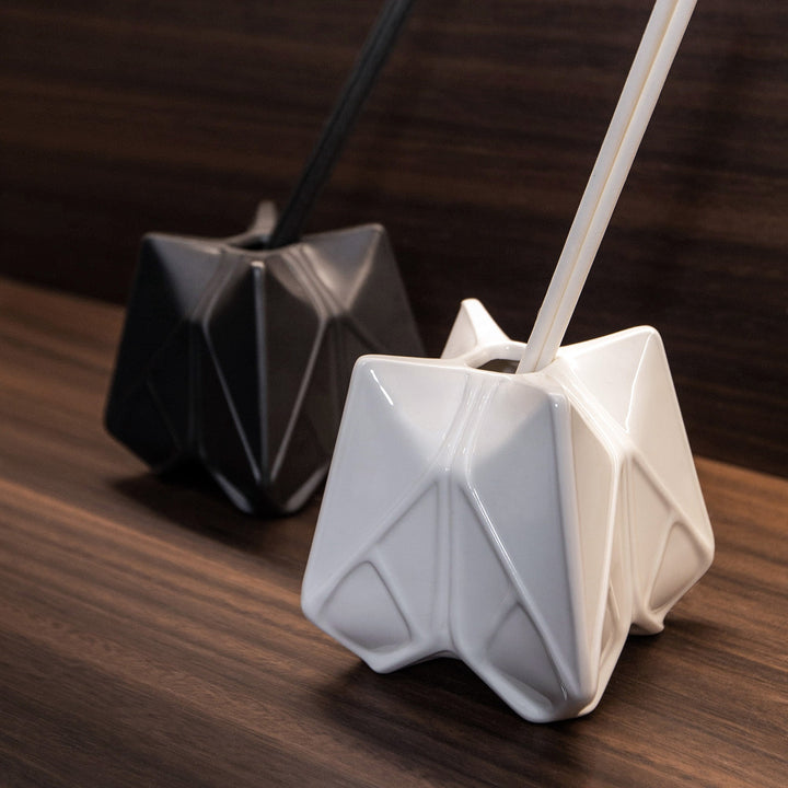 Prime Reed Diffuser — white glossy diffuser with reeds in front of a black diffuser on a wood surface
