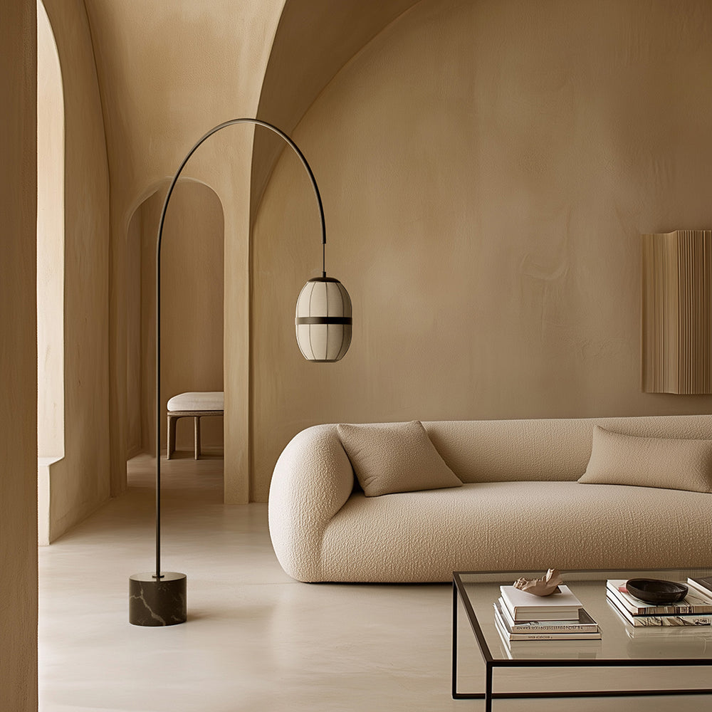 Pull Floor Lamp arching over a cream boucle sofa and glass coffee table in a vaulted plaster room