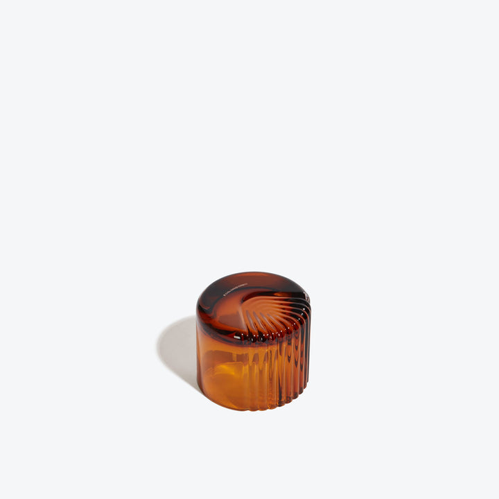 Pulse Tealight Holder X — amber tealight holder turned on its side showing the radiating ribs on its base