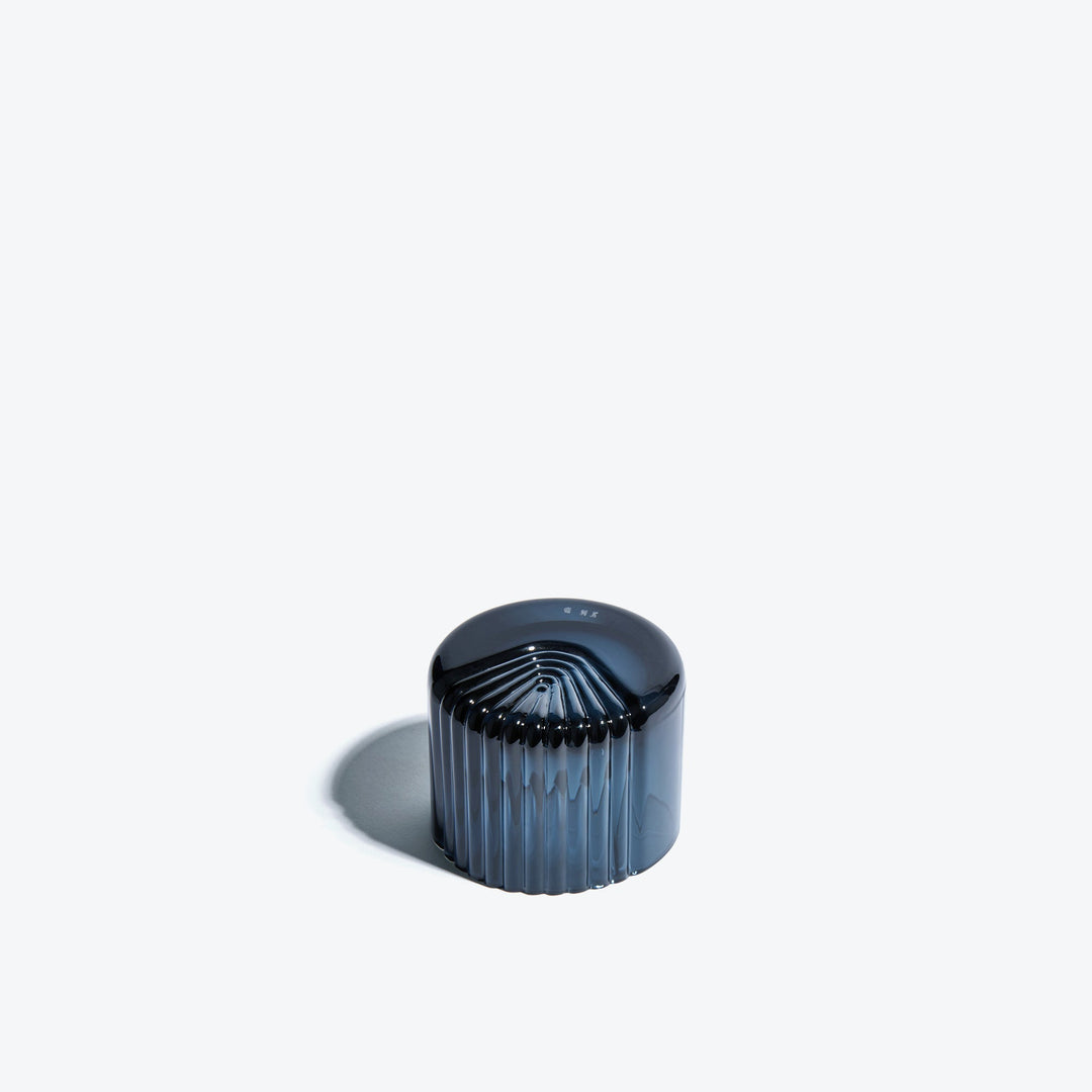 Pulse Tealight Holder X — dark blue tealight holder turned on its side showing the radiating ribs on its base