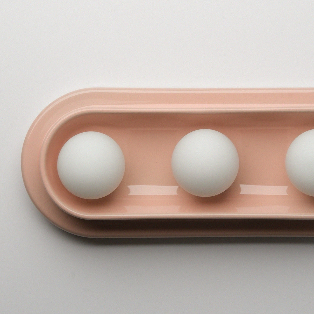 Blush ceramic tray with matte white spheres, minimalist home decor