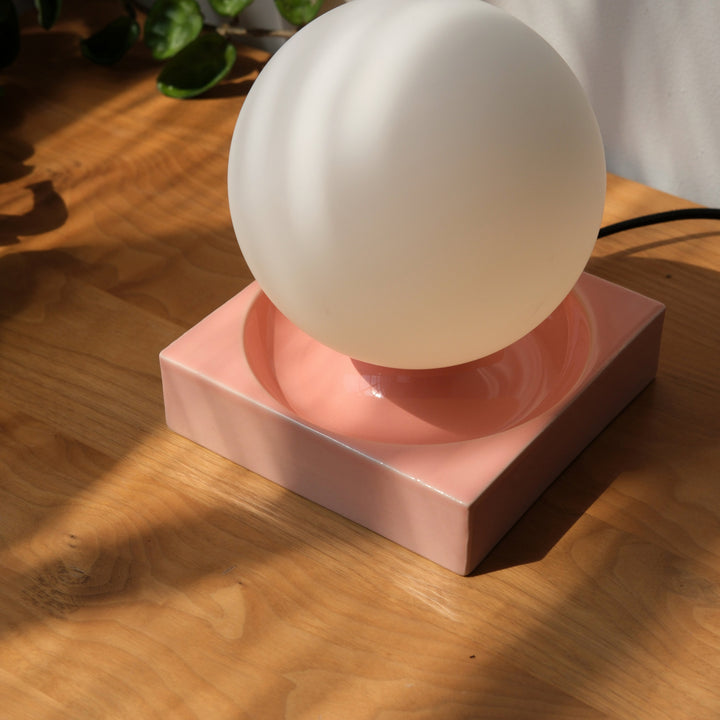 Glossy pink ceramic base with frosted glass sphere lamp