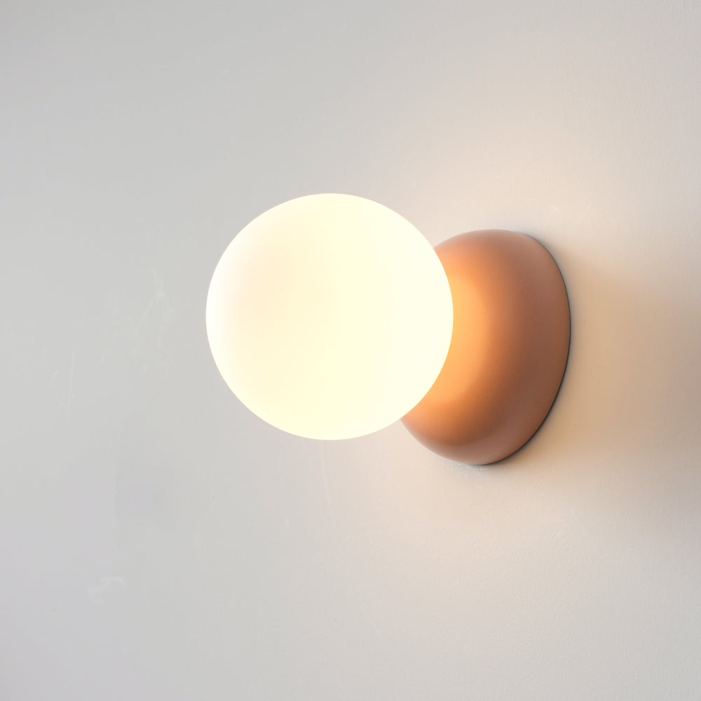 Opaline glass globe sconce with matte pink base, modern wall lighting