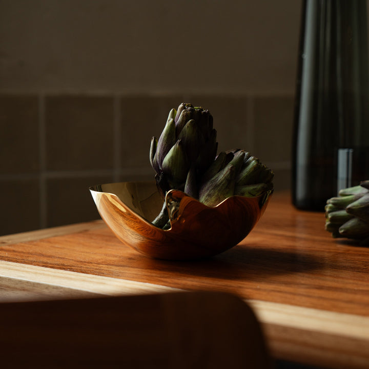 Serenity Bowl — gold bowl holding artichokes on a wooden counter in soft daylight