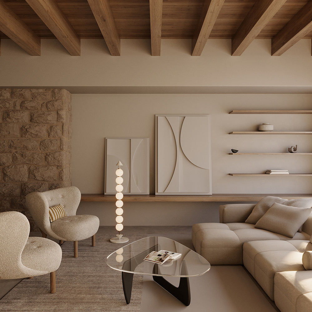 Soko Floor Lamp glowing beside a boucle armchair and glass coffee table under timber beams
