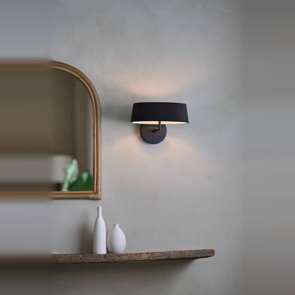 Halo Wall Sconce by Seed Design in Black, styled in a room setting