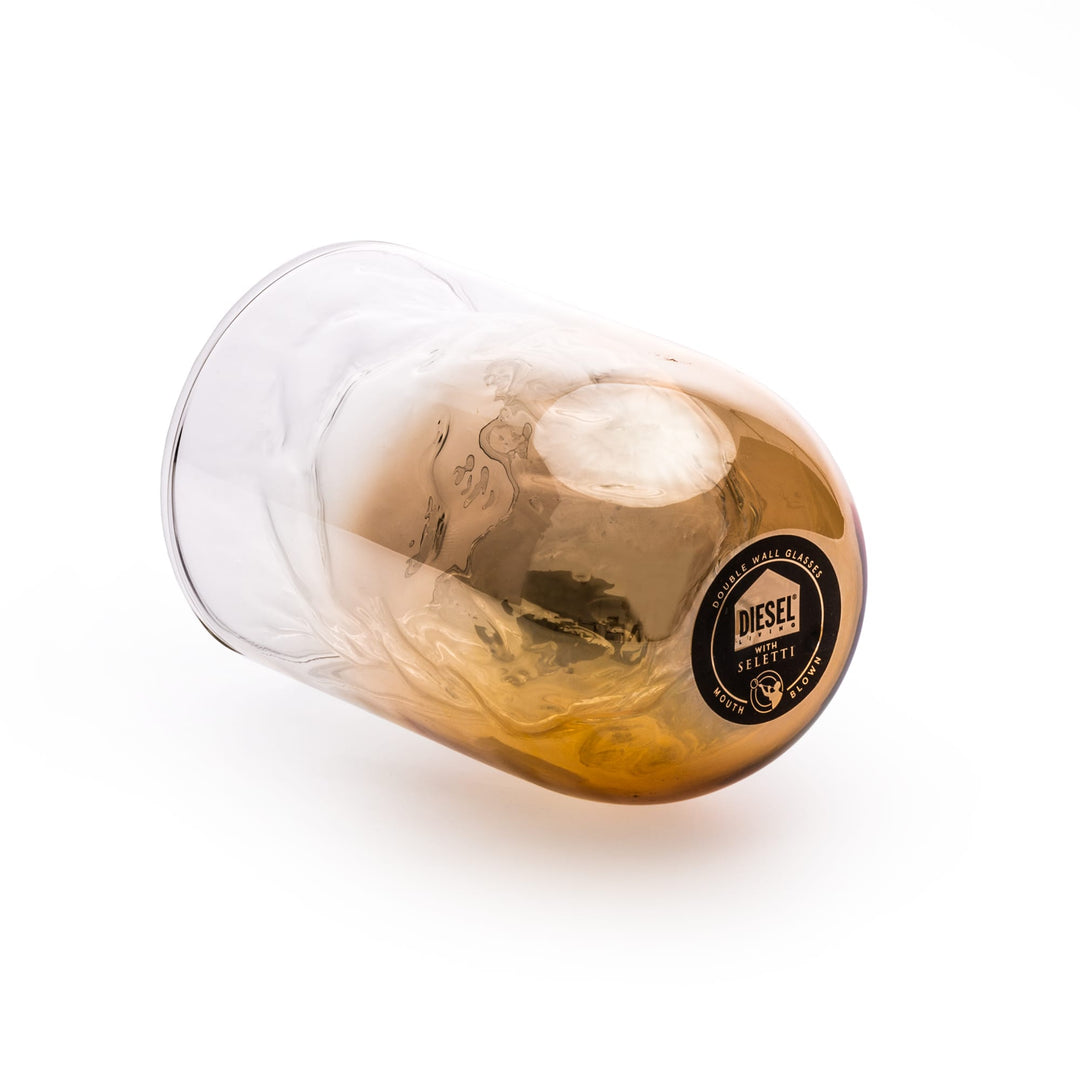 Seletti Cosmic Diner Meteorite Glass Tall, tall glass lying on its side, amber base and Diesel label visible