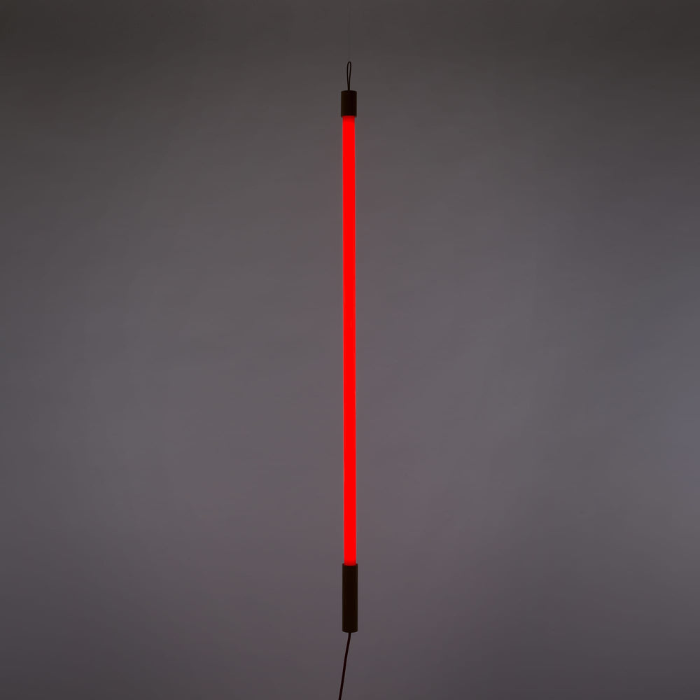 Seletti Linea LED Red, red tube lit upright against a gray wall