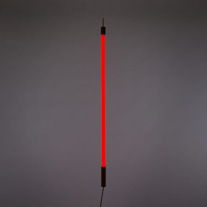 Seletti Linea LED Red, red tube lit upright against a gray wall