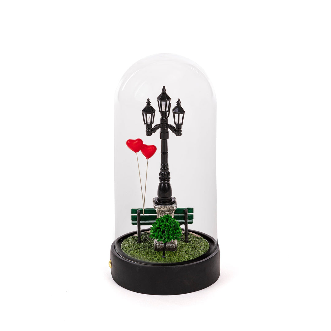Seletti My Little Valentine, park bench under a street lamp with red heart balloons, inside a glass dome
