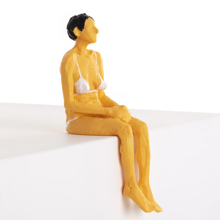 Seletti Love Is a Verb Penelope Figurine, side view of the seated woman, legs over the edge