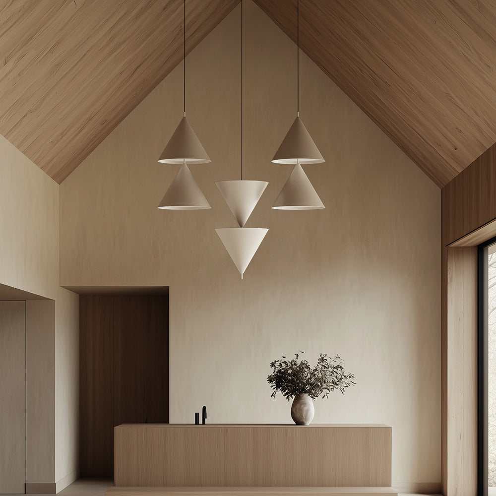 Stacked Trag Pendant Lamp cones in beige hanging under a pitched wood ceiling above a reception counter