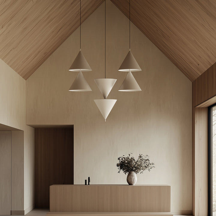 Stacked Trag Pendant Lamp cones in beige hanging under a pitched wood ceiling above a reception counter