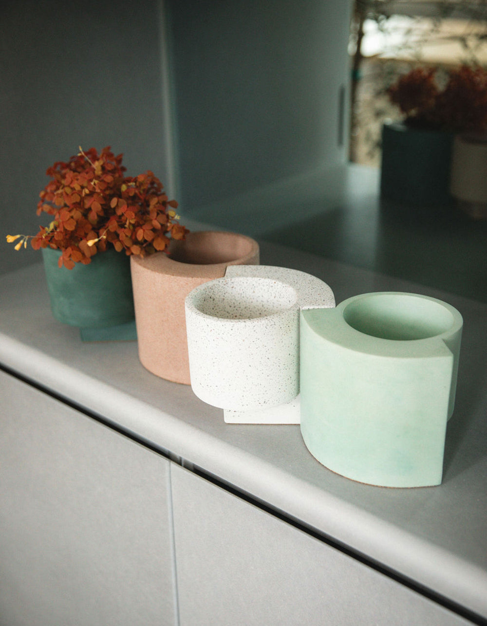 Curved terrazzo planters in pastel hues by Kelsey Cherry, styled on a modern surface