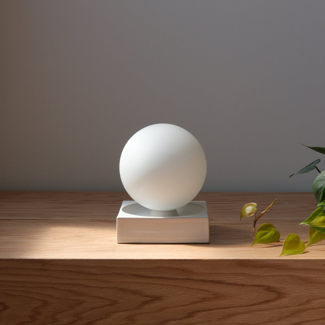 Frosted glass orb lamp on ceramic base, minimalist home decor