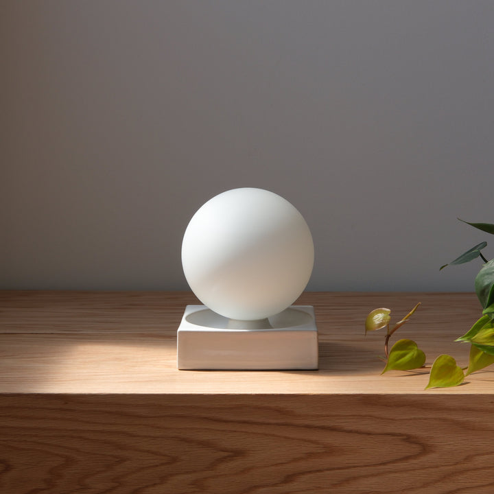 Frosted glass orb lamp on ceramic base, minimalist home decor