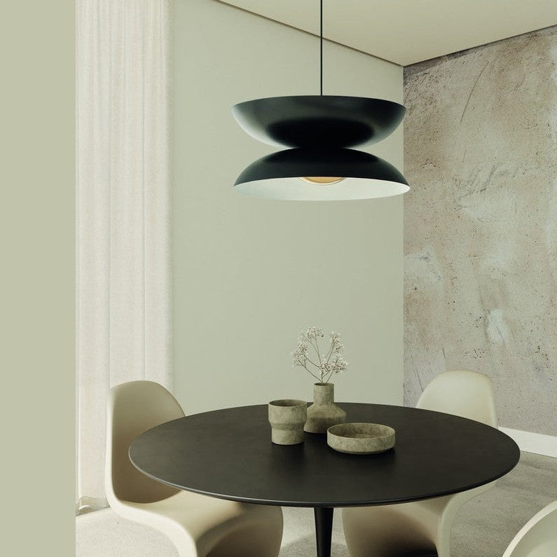 Yoyo Pendant in matt black hanging above a round dining table with sculptural cream chairs