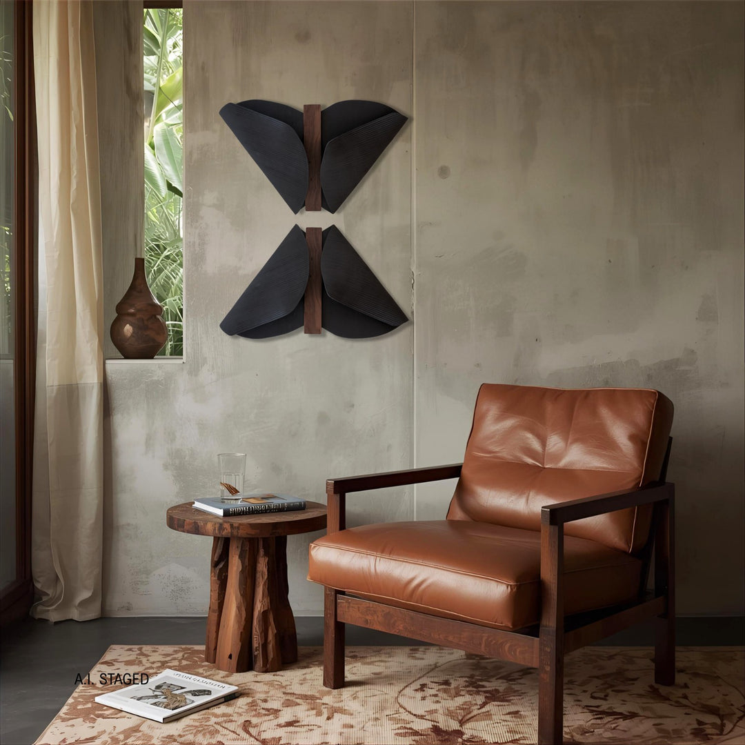 Abundance Duo II in black stoneware on a concrete wall above a leather lounge chair