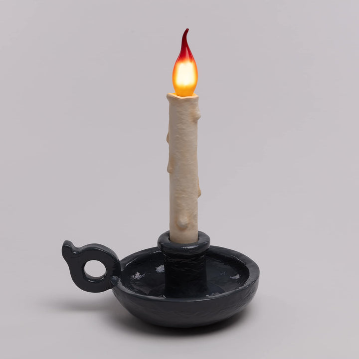Seletti Bugia LED Candle Lamp Grey, charcoal gray base on a gray backdrop, flame bulb lit