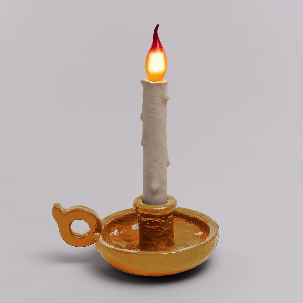 Seletti Bugia LED Candle Lamp Gold, gold base on a gray backdrop with the candle flame glowing