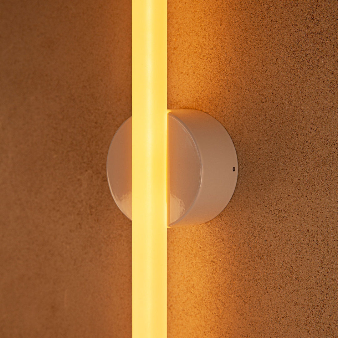 Modern wall sconce with warm glow, sleek white design, minimalist elegance