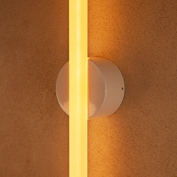 Modern wall sconce with warm glow, sleek white design, minimalist elegance