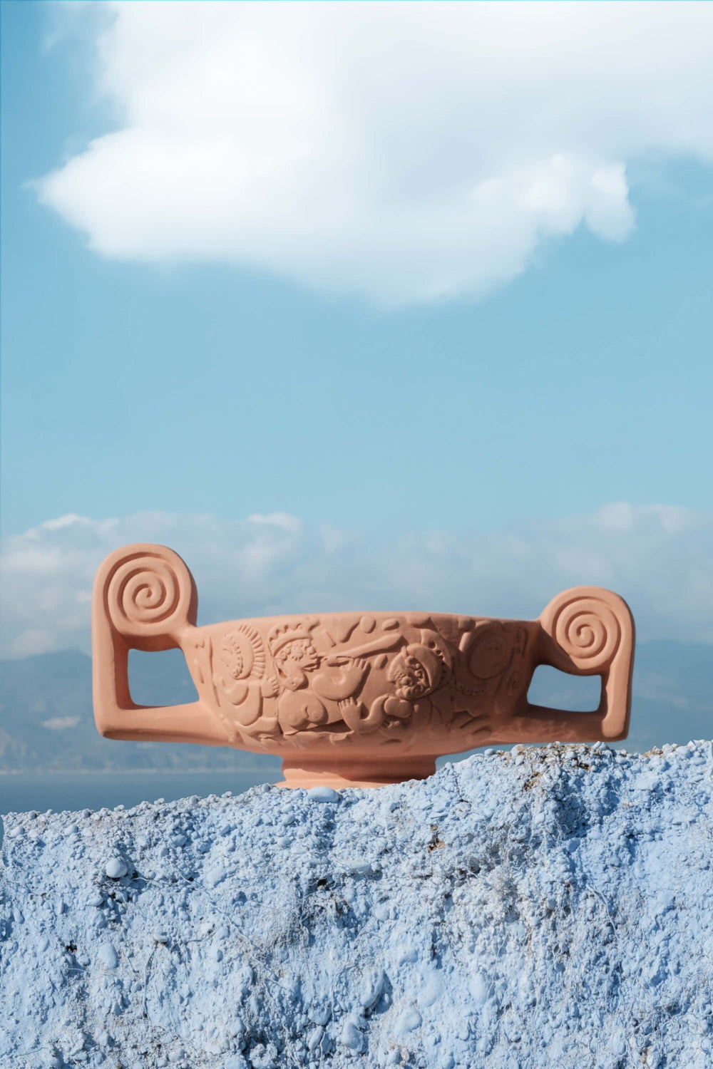 Seletti Magna Graecia Terracotta Centerpiece, the centerpiece balanced on blue rock under a summer sky