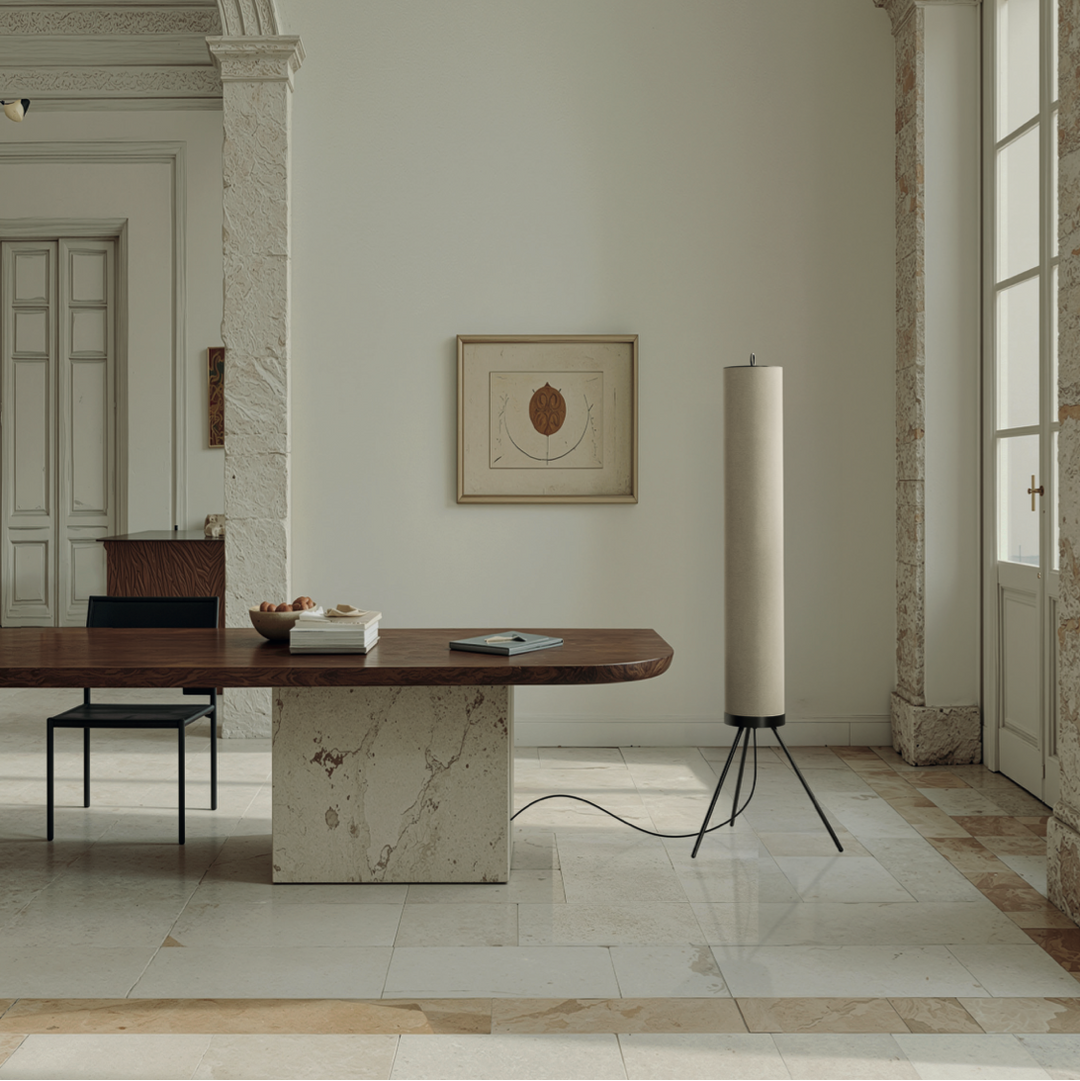 Elegant interior with a long wooden table, marble floor, and tall lamp.