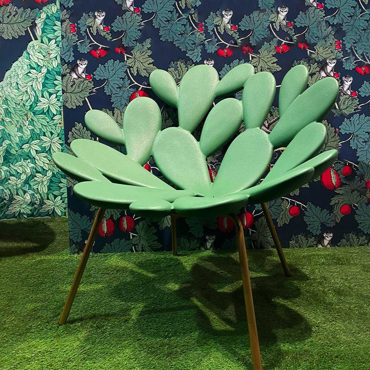 Filicudi armchair by Marcantonio, sculpted green polyethylene with brass legs, botanical setting