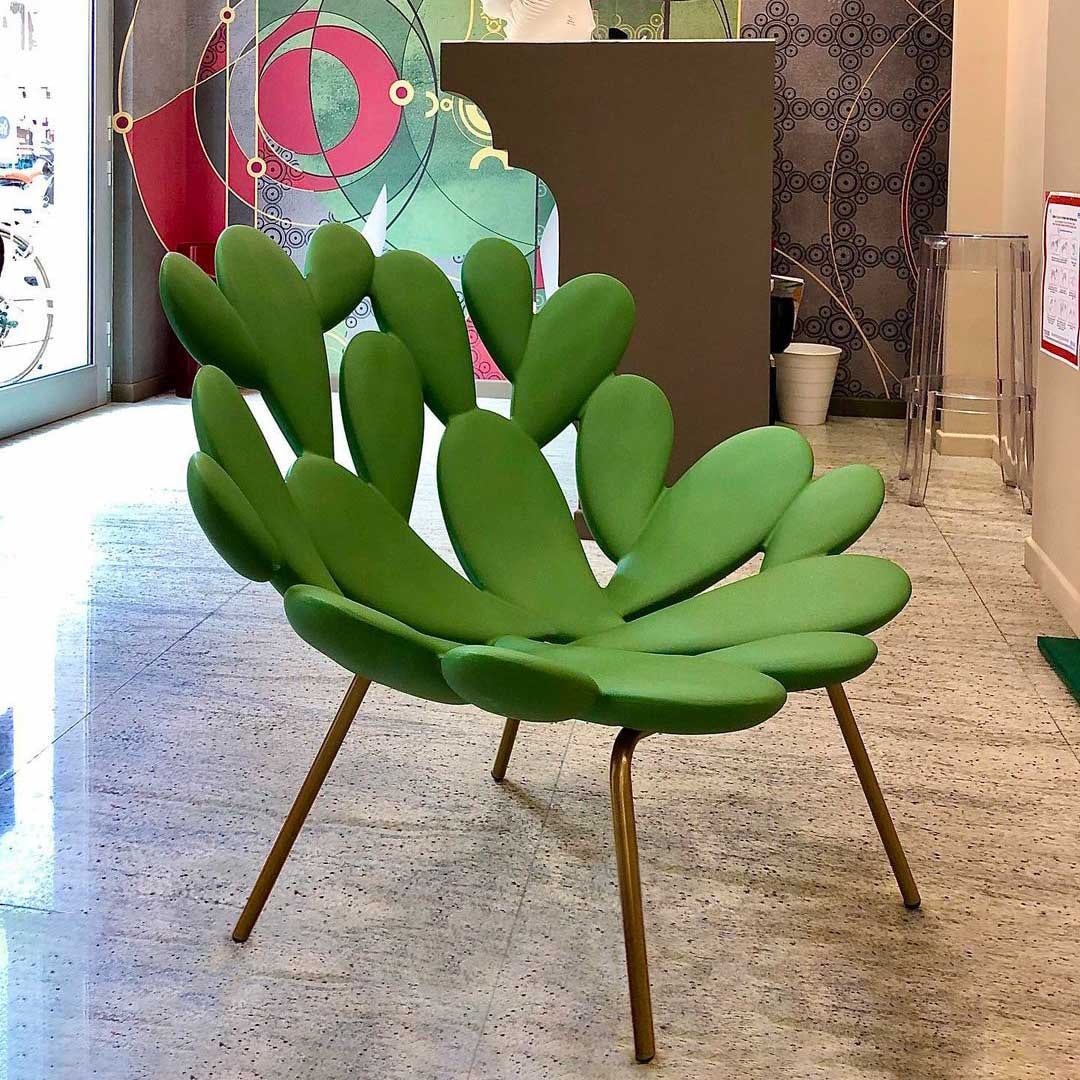 Filicudi armchair by Marcantonio, sculpted green upholstery with gold legs in a modern setting