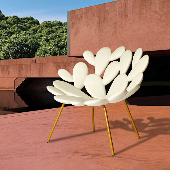 Filicudi armchair by Marcantonio with sculpted white seat and gold legs, modern outdoor setting.