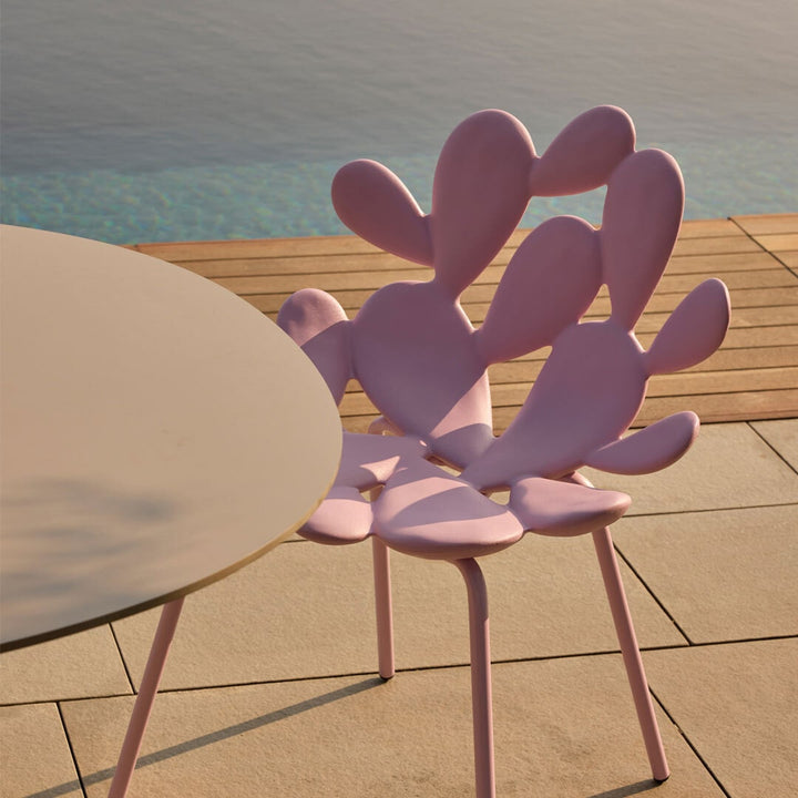 Filicudi chair by Marcantonio in pastel pink resin beside a poolside table