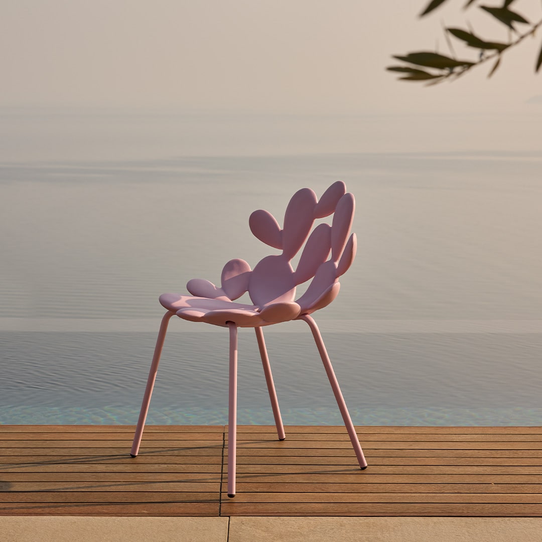 Filicudi chair by Marcantonio in pink, sculptural resin design by a serene poolside