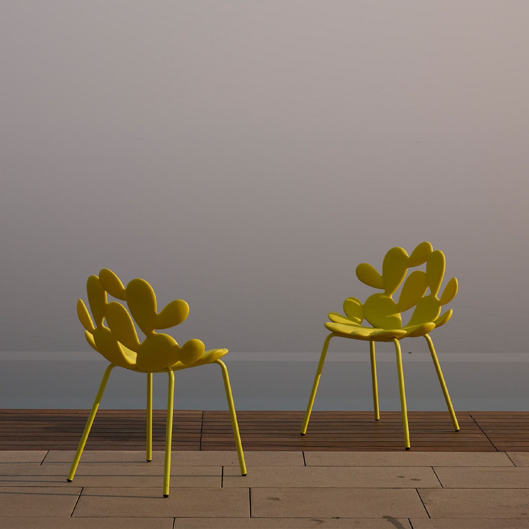 Filicudi outdoor chairs by Marcantonio in sculptural yellow metal, minimalist lakeside setting