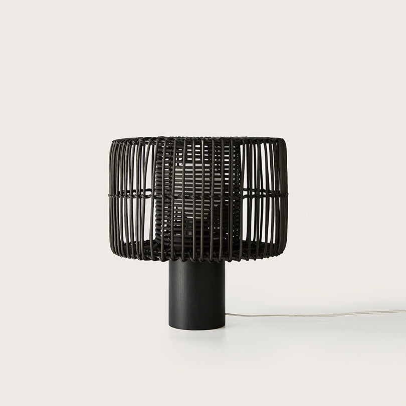 Hedula Table Lamp in black with open rattan fibre shade on a cylindrical wooden base, unlit, by Aromas del Campo