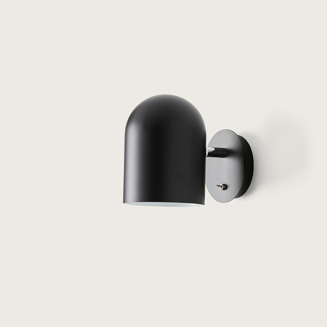 Luca Wall Lamp in matt black, side view of the rounded shade and wall plate with toggle switch