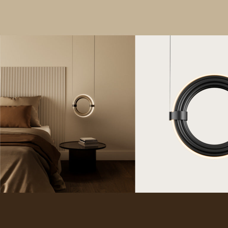 Elli Pendant Lamp glowing beside a bed above a round dark side table with stacked books