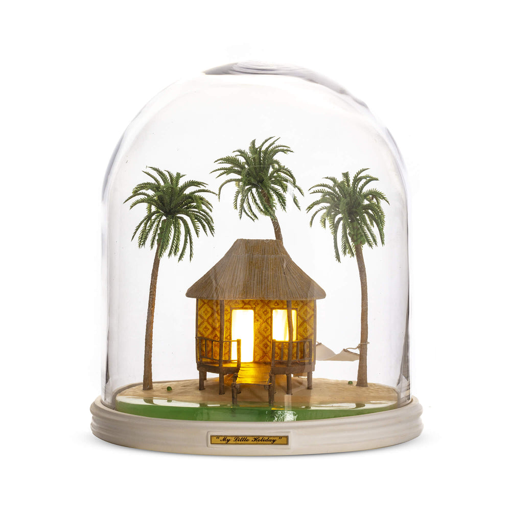 Seletti My Little Holiday, the hut's windows glowing warm among the palms