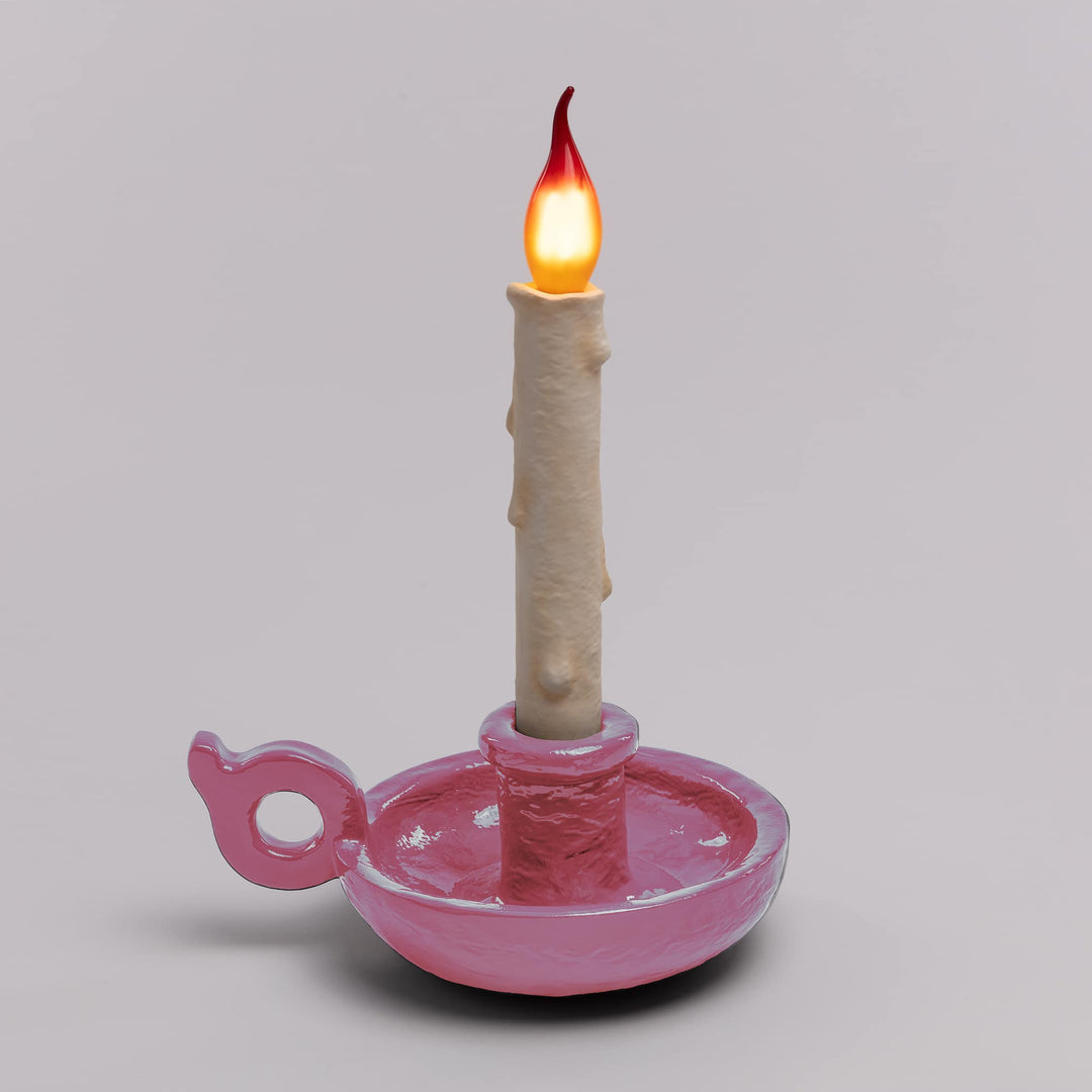 Seletti Bugia LED Candle Lamp Light Pink, pink base on a gray backdrop with the flame bulb glowing