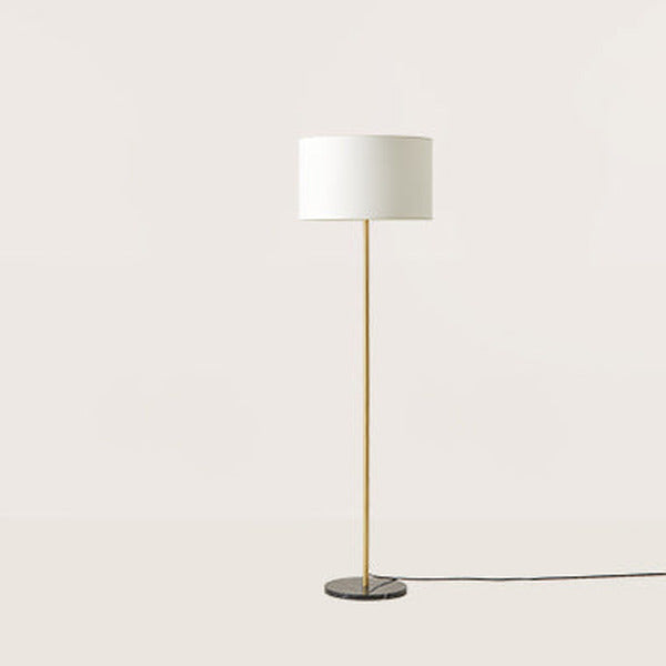 Hedra Floor Lamp in a matt brass finish with white drum shade and round black marble base, side view