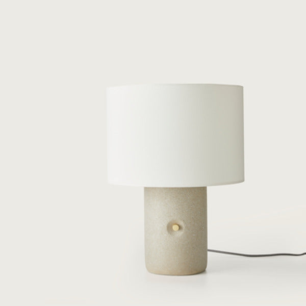 Sand Table Lamp front view, speckled terrazzo base with brass knob and white drum shade, unlit