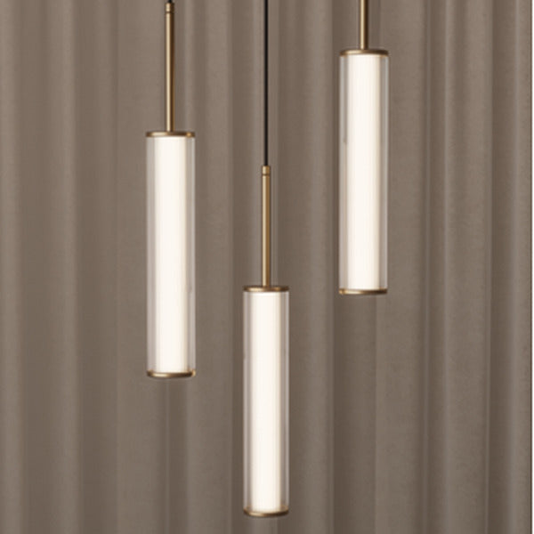 Ison Pendant Lamp trio in aged gold, lit, against soft taupe curtains