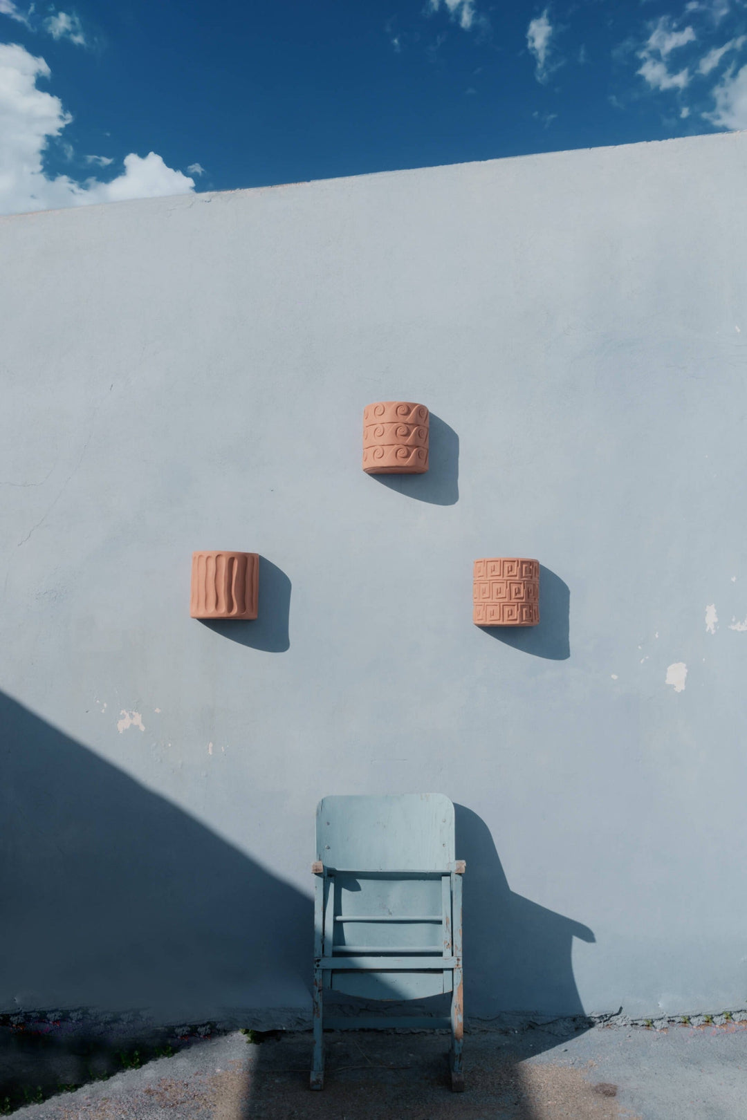 Seletti Magna Graecia Terracotta Wall Vase Dorico, three Magna Graecia wall vases on a blue wall